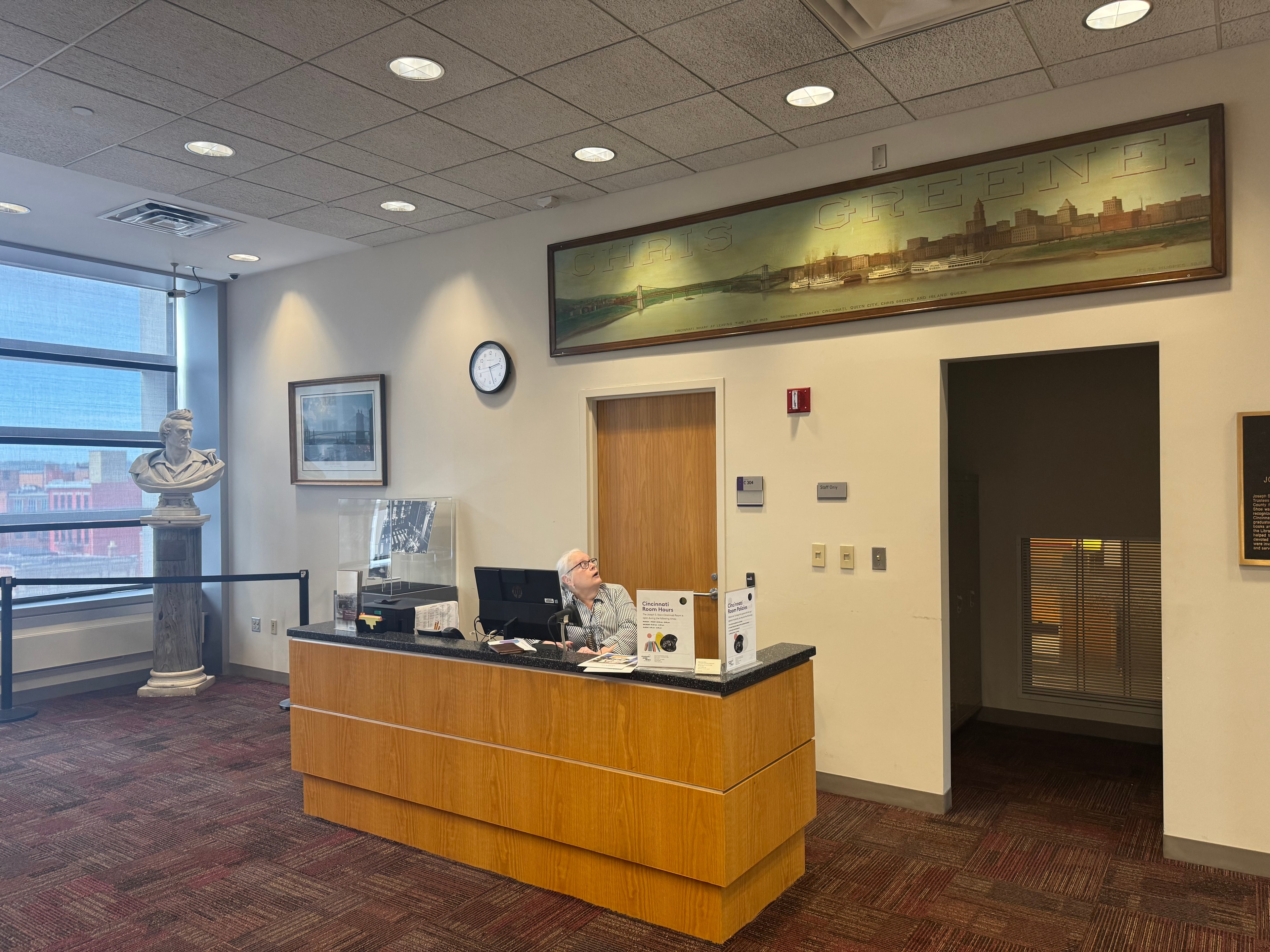 Cincinnati Room reference desk with librarian and historical panorama artwork