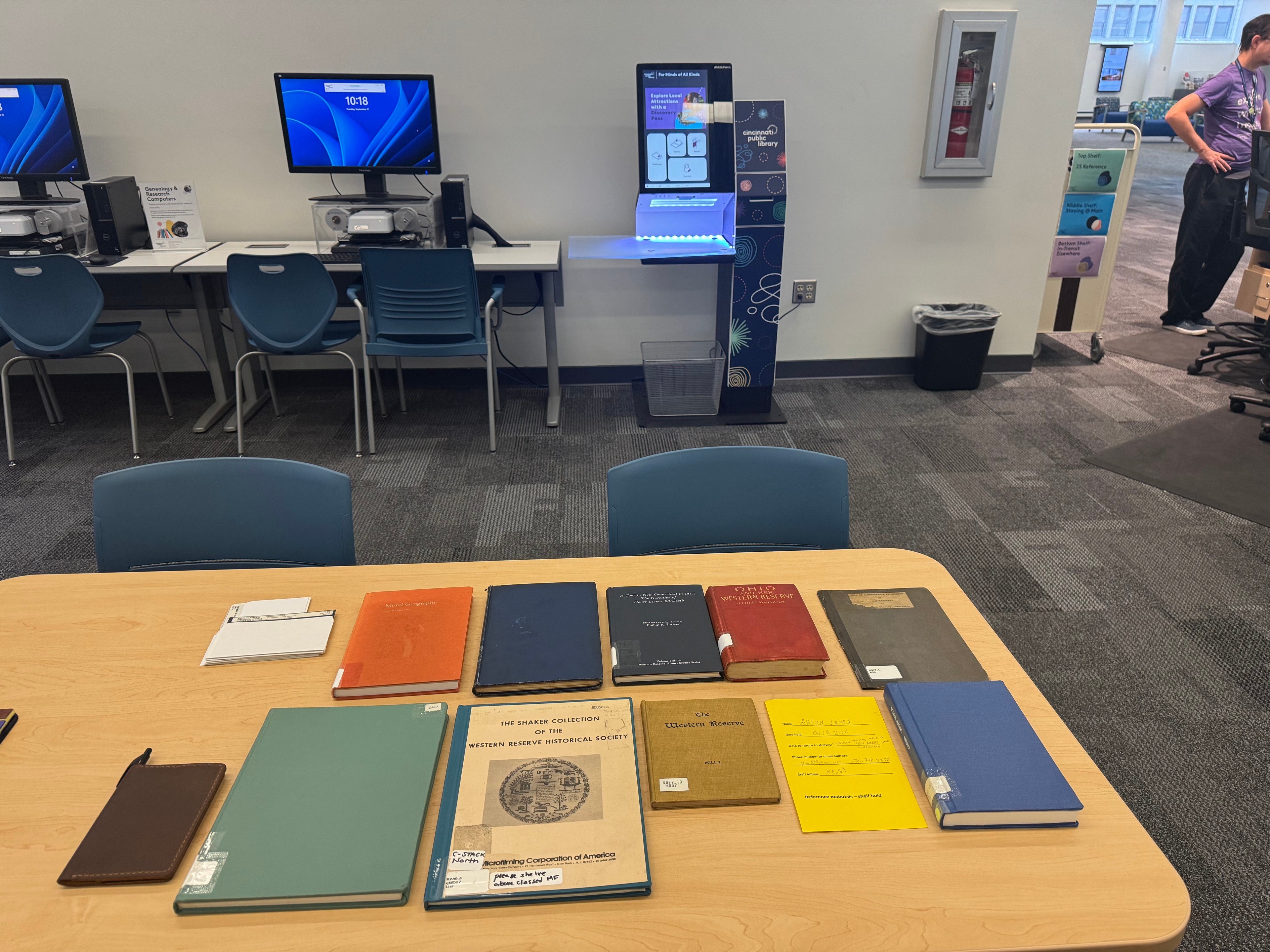 Cincinnati Public Library reference materials table with historic books, archival resources, workstations, and discovery kiosk